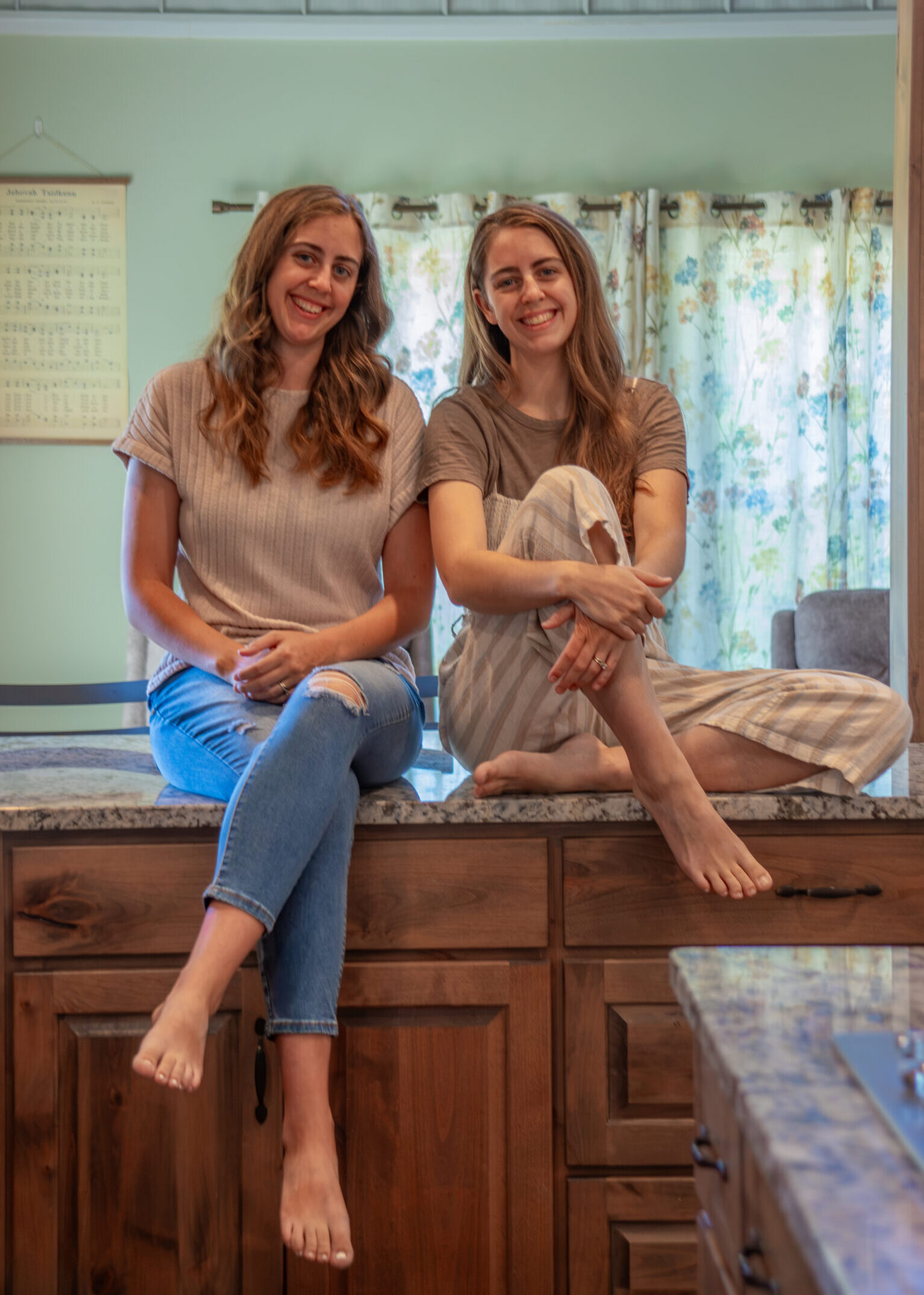 Two women sitting on kitchen counter